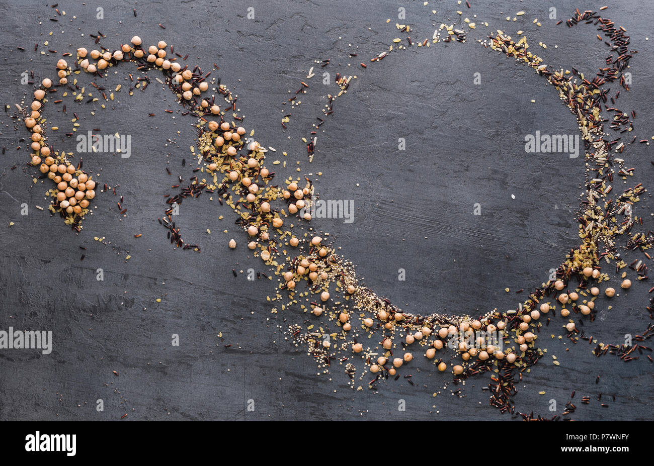 Pattern of different seeds for a healthy food on dark background. Seeds of quinoa, chia, bulgur, chickpeas, black rice and brown rice, top view Stock Photo