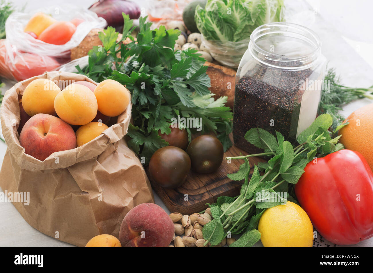 Set of healthy food. Black quinoa seeds, nut, various vegetables and fruits on a white wooden table Stock Photo