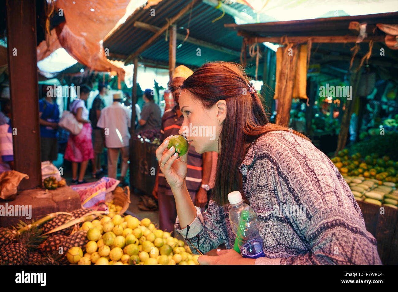 Young woman chooses fruits at the local African market Stock Photo