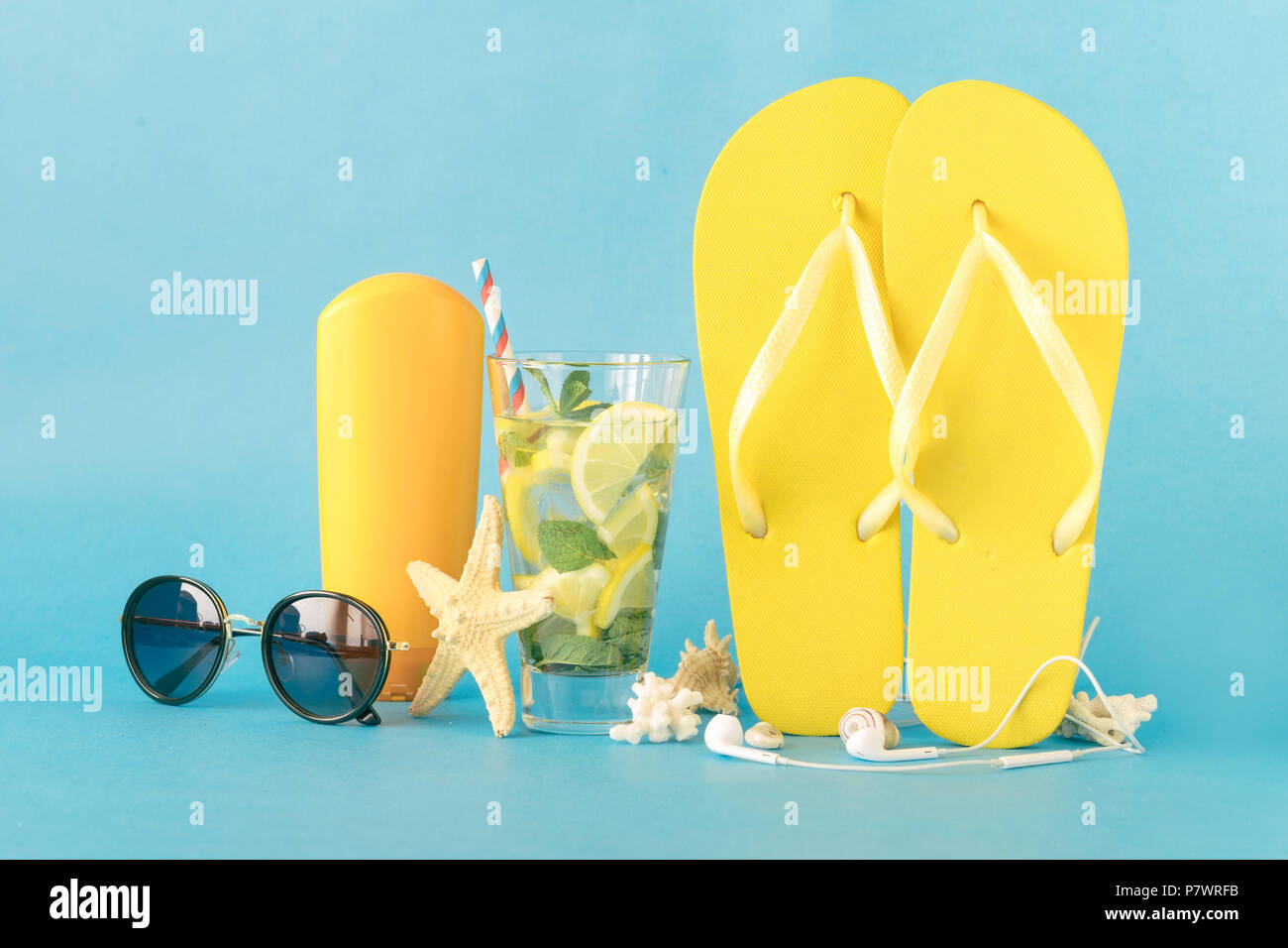 Beach accessories with summer refreshing cocktail on blue background. Colorful summer background Stock Photo