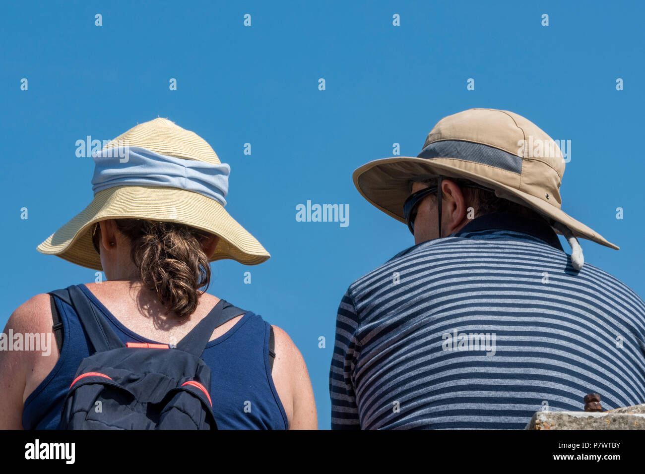 a man and a woman couple wearing sun hats on a hot summers day in a ...
