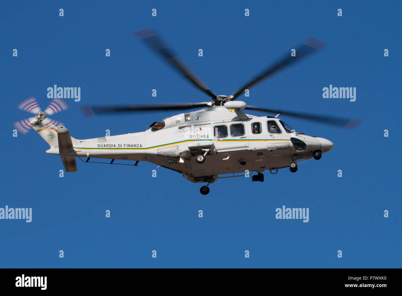 Helicopter flying. AgustaWestland AW139 of the Italian Guardia di Finanza or Customs Guard in flight against a clear blue sky Stock Photo