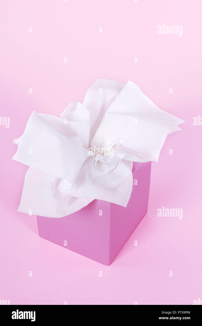 Paper tissues in blank box on a soft pink background. Stock Photo