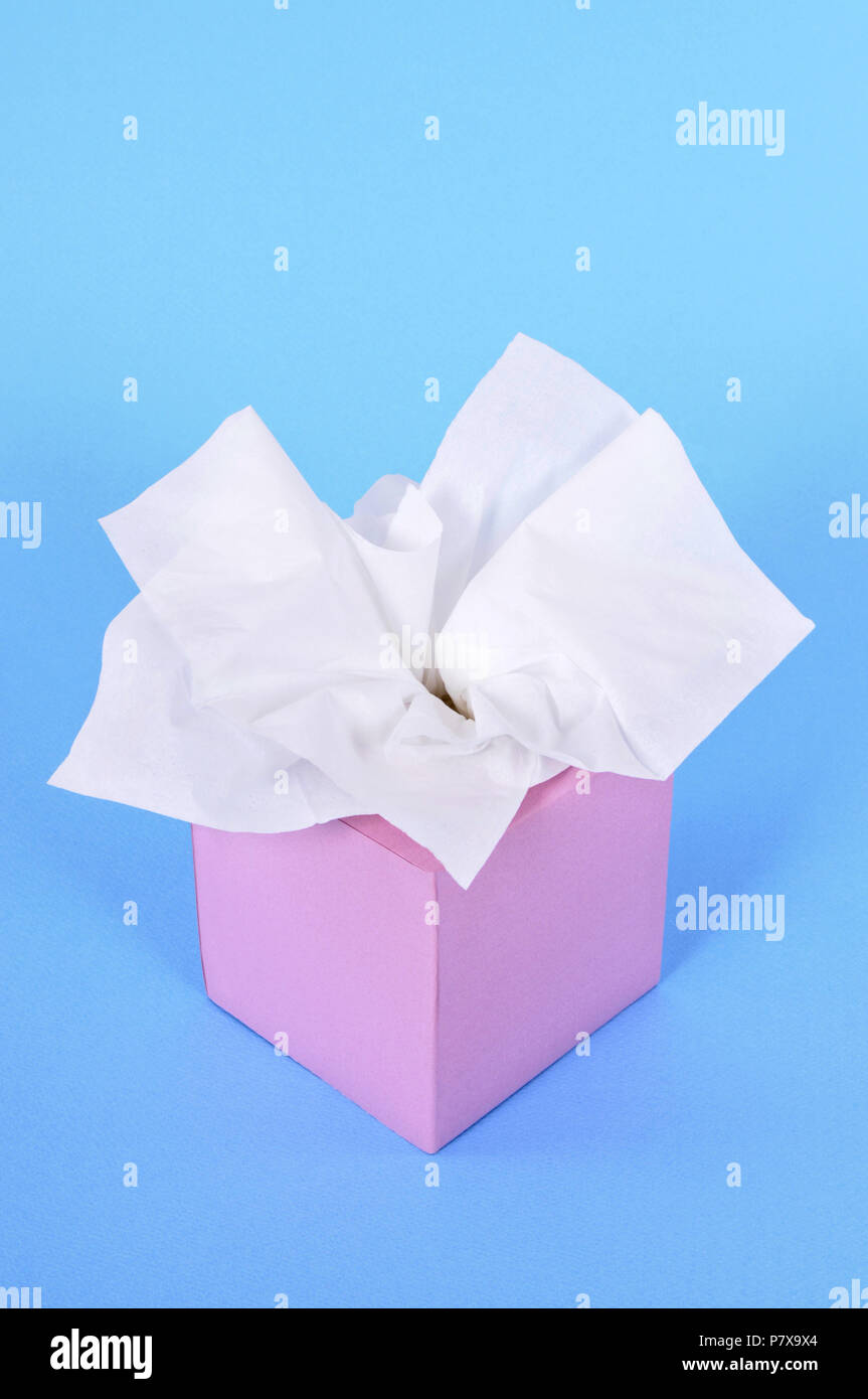 Kleenex style tissues in blank box on a blue background. Stock Photo