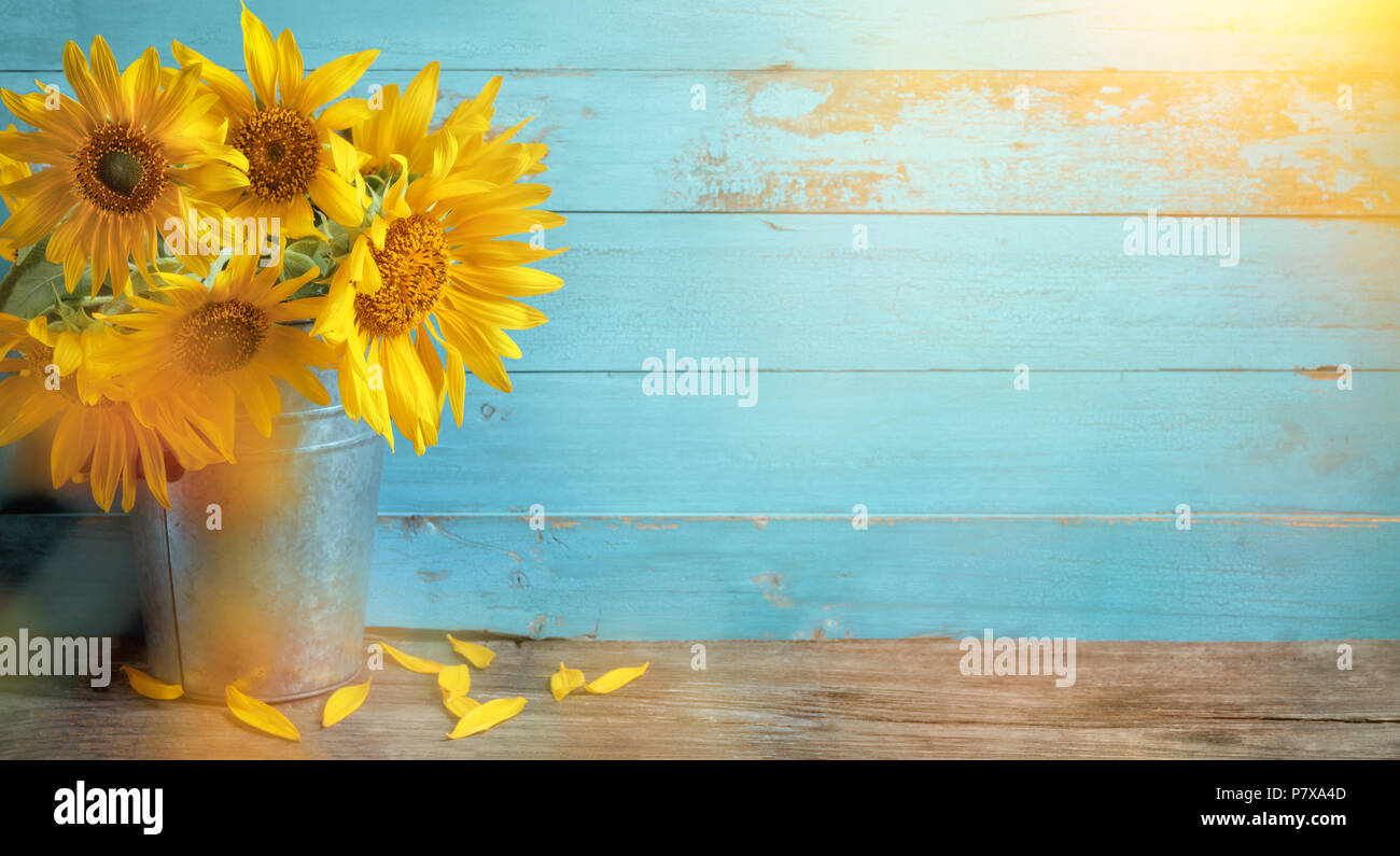 Sunflower flowers in rustic vase on wooden table and rustic background Stock Photo