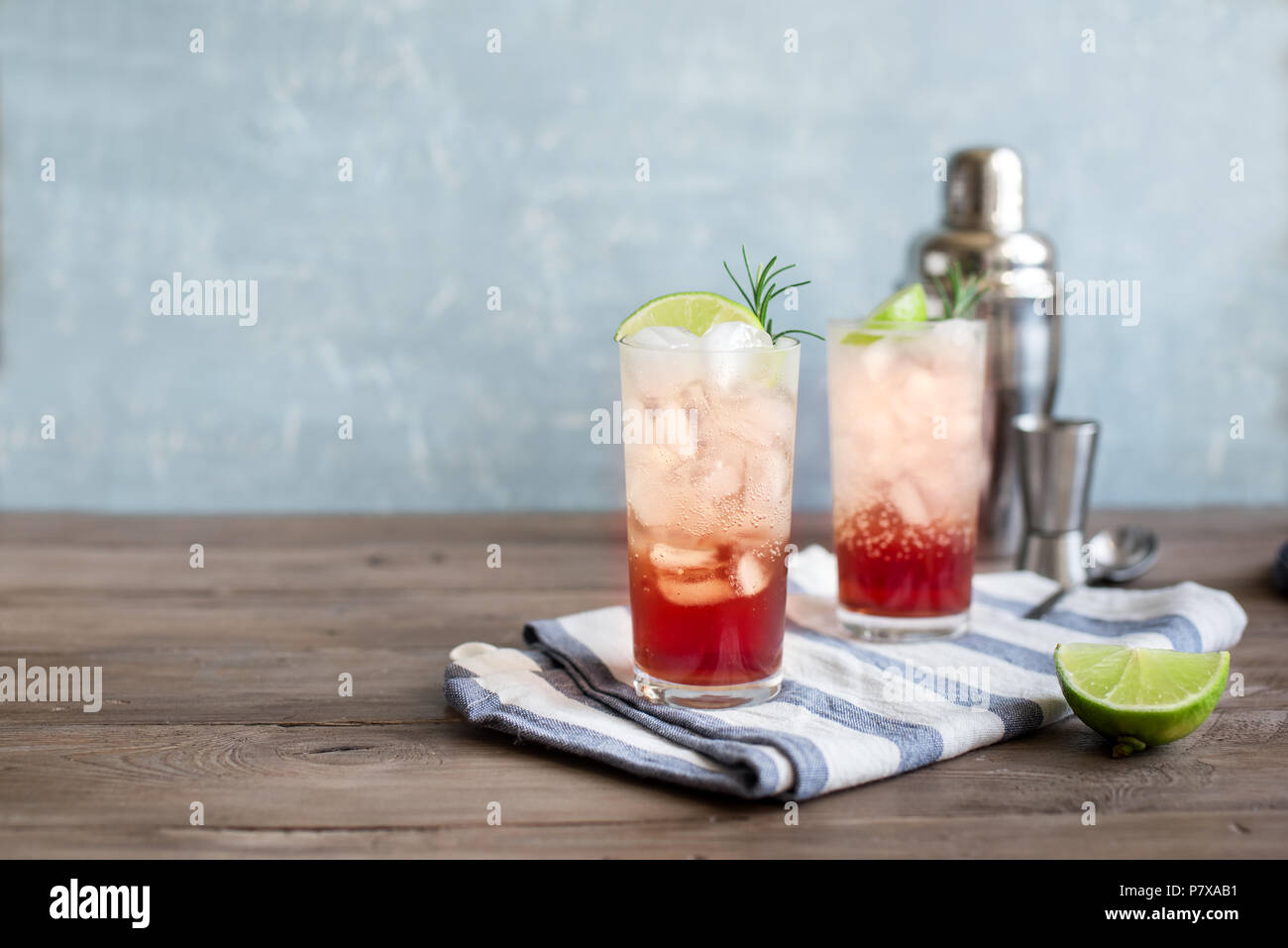 Sloe Gin Fizz Cocktail. Pink cold alcohol drink with ice, lime and soda