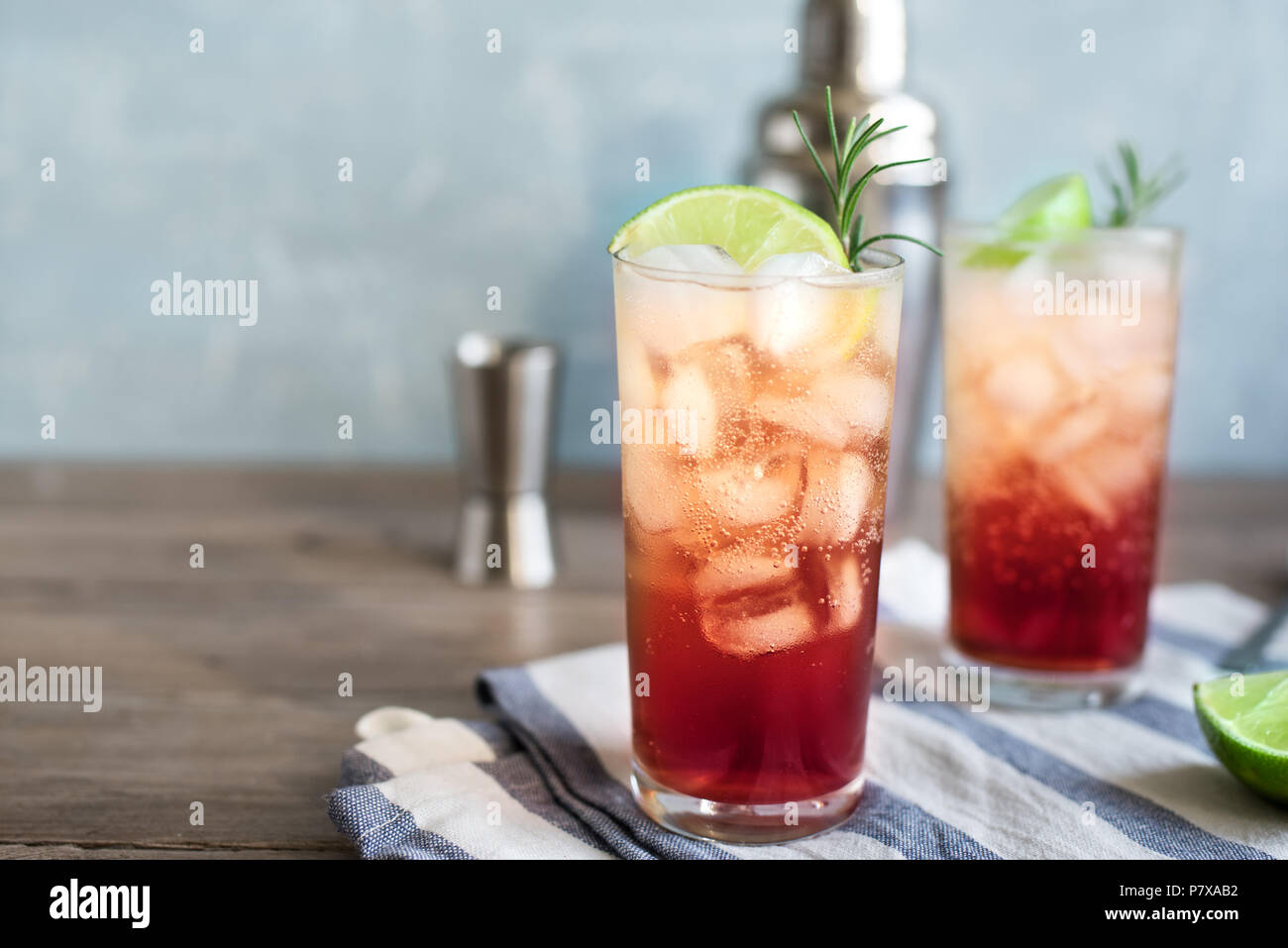 Sloe Gin Fizz Cocktail. Pink cold alcohol drink with ice, lime and soda, copy space. Stock Photo