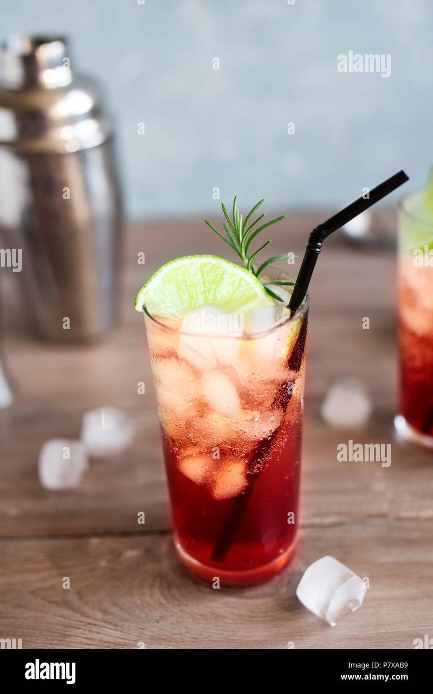 Sloe Gin Fizz Cocktail. Pink cold alcohol drink with ice, lime and soda