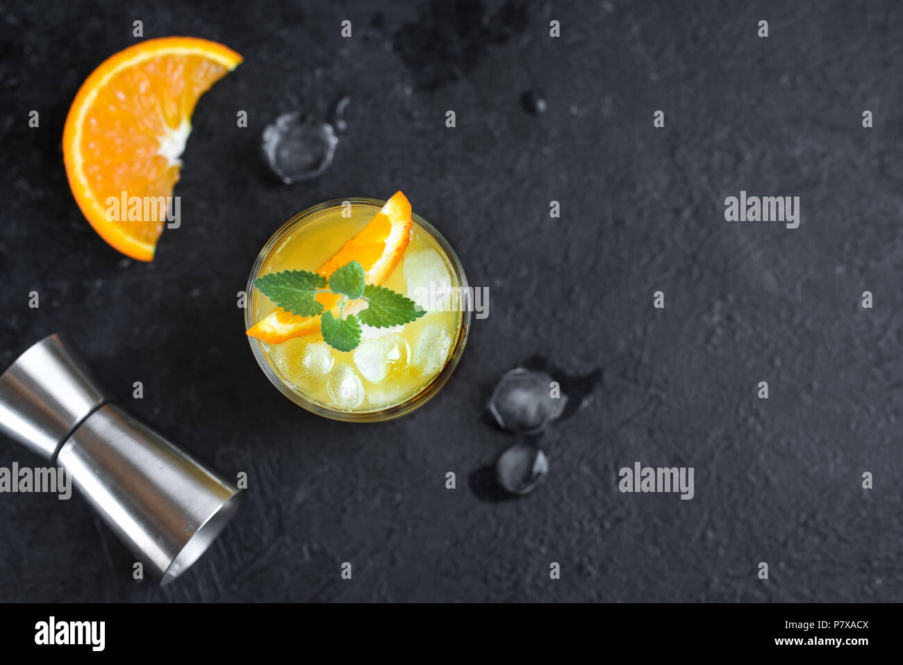 Gin and orange juice cocktail on black background, top view. Refreshing