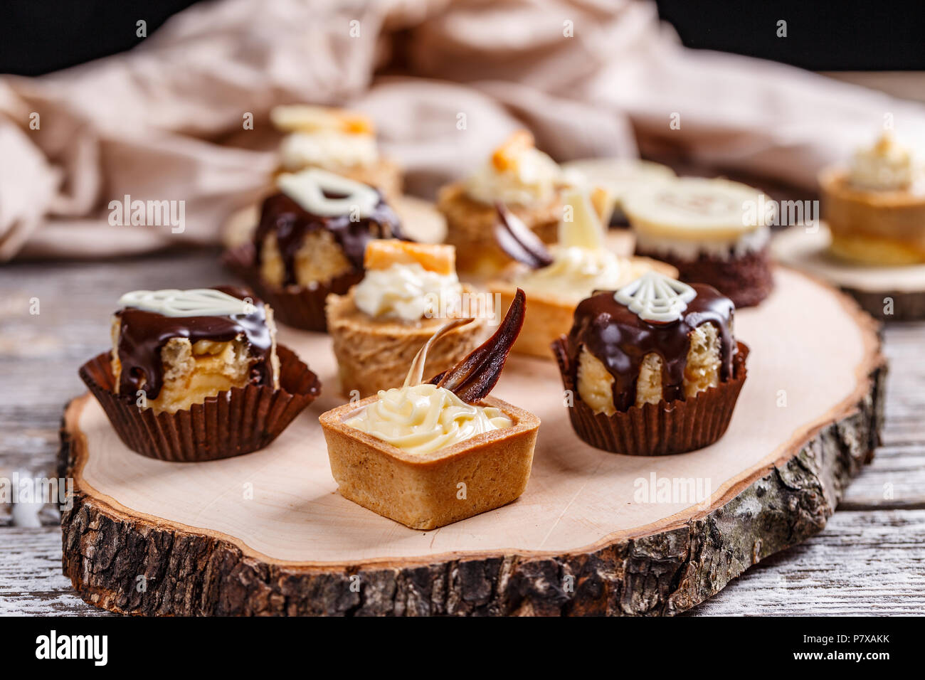 Different cakes standing on a wooden board Stock Photo