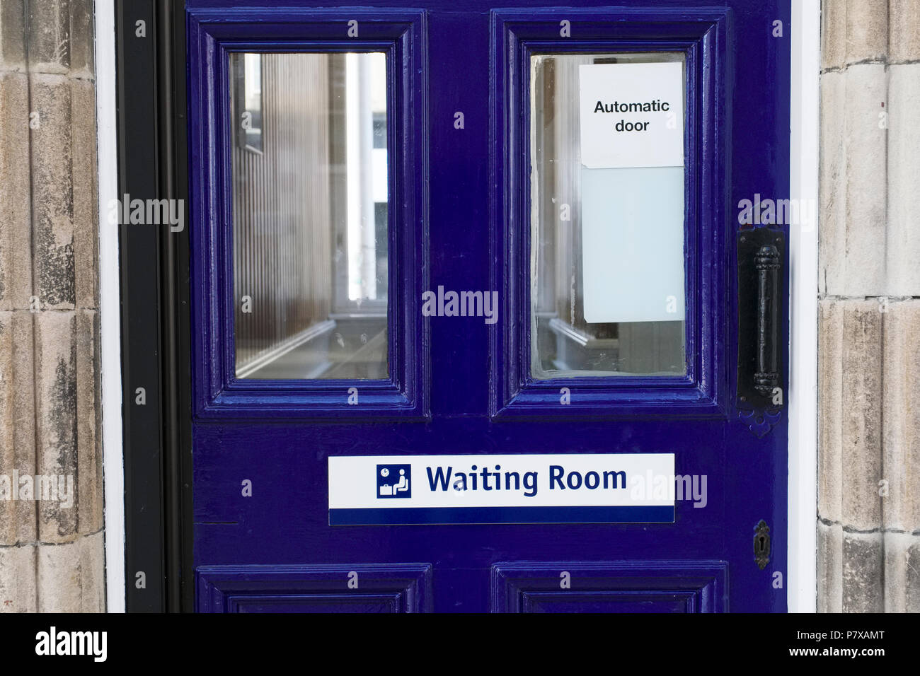 Waiting room sign on blue door at train station Stock Photo
