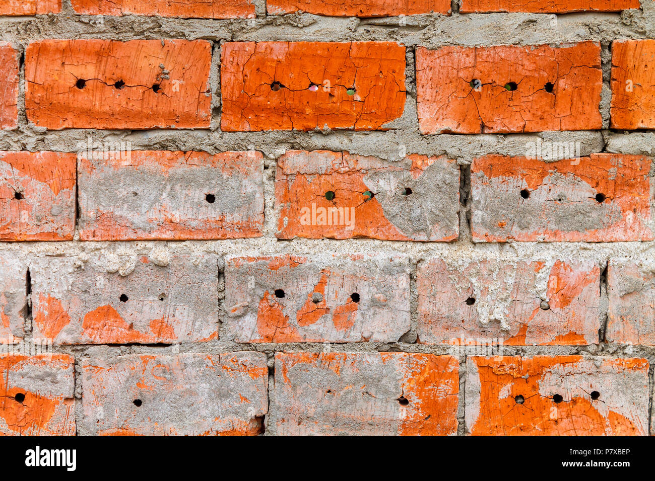 Wall of red brick with holes and gray cement Stock Photo Alamy