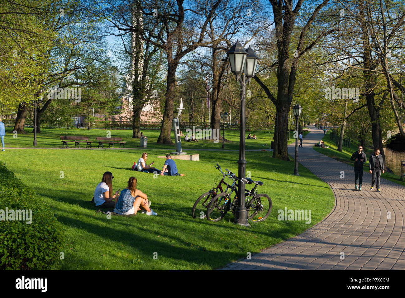 Girls sitting on the lawns in Bastion Hill park, Riga, Latvia Stock Photo