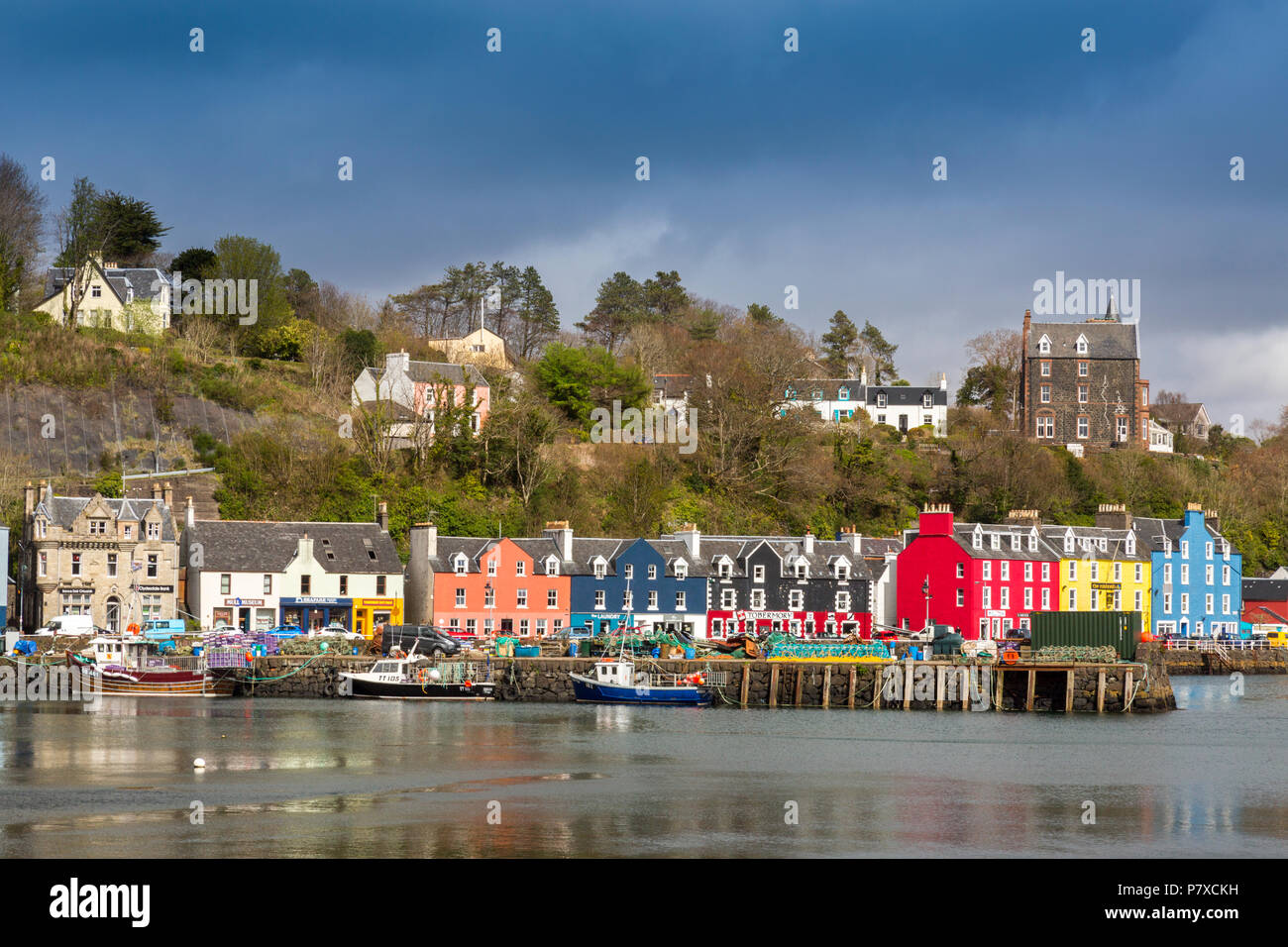 Threatening skies over the colourful shops and houses that line the historic harbour in Tobermory, Isle of Mull, Argyll and Bute, Scotland, UK Stock Photo