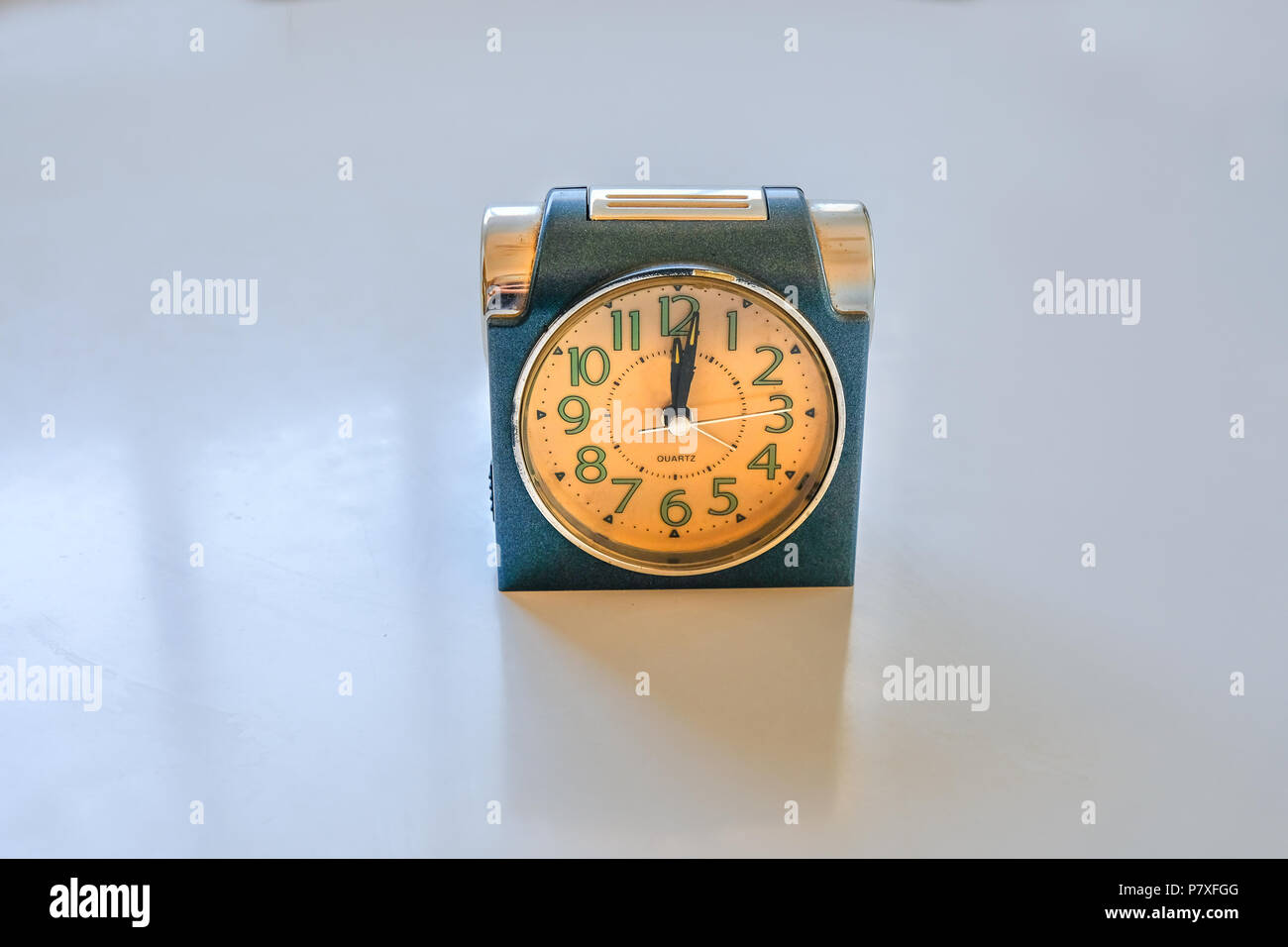 Antique alarm clock on a plain background. Luminous numbers and classic