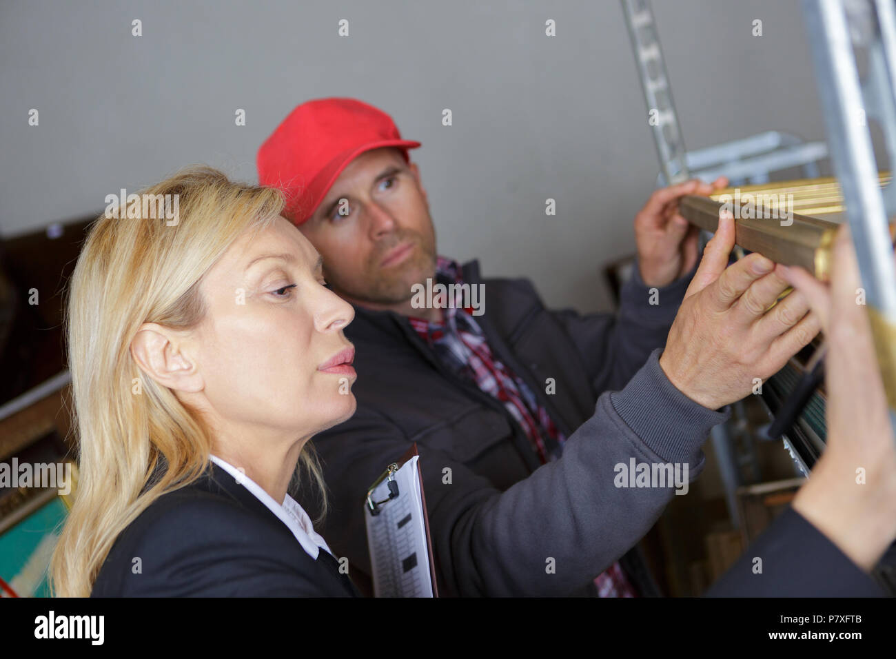 forewoman and worker inspecting shelves in workshop Stock Photo