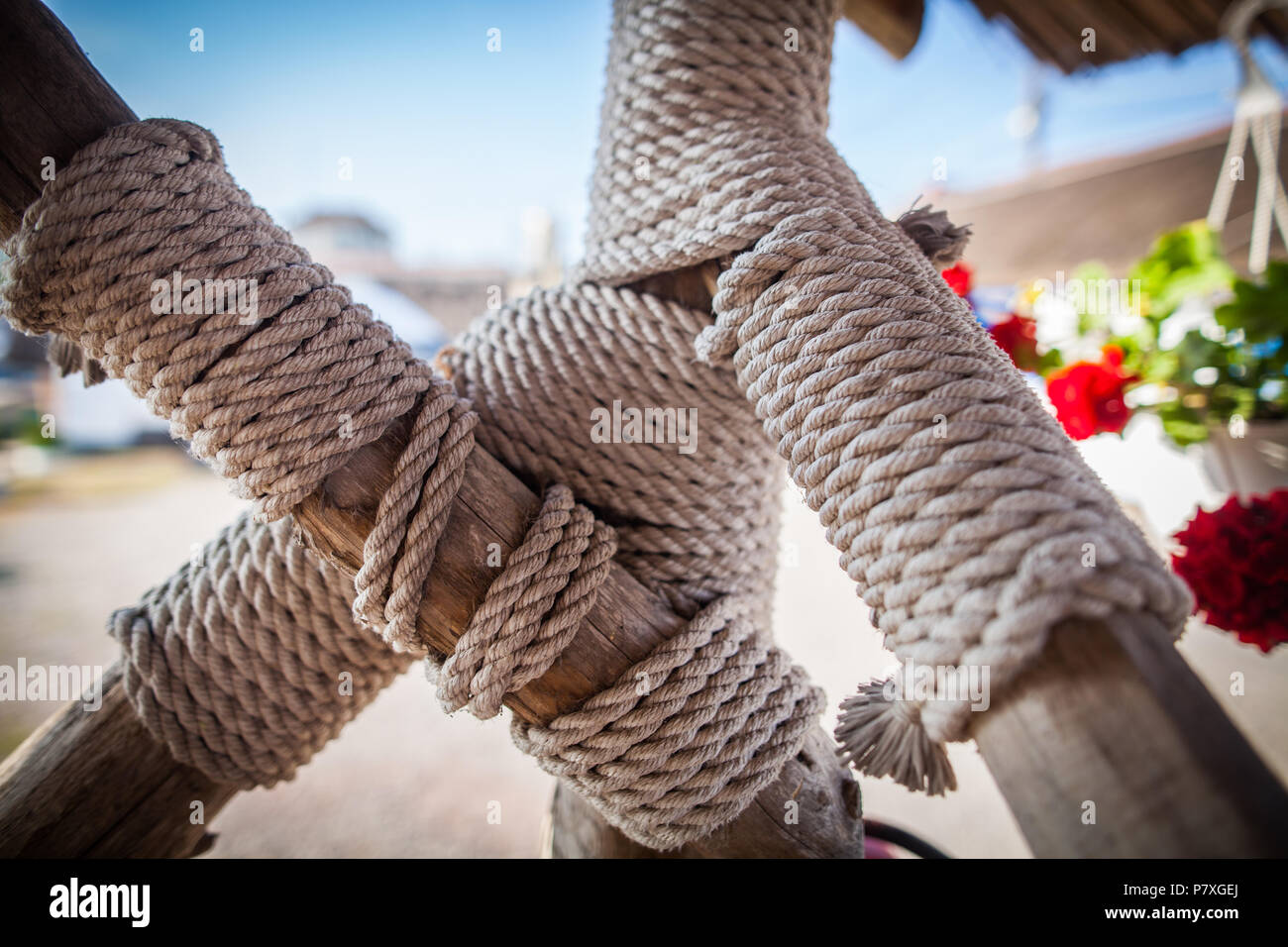 Large rope wrapped around wood poles Stock Photo