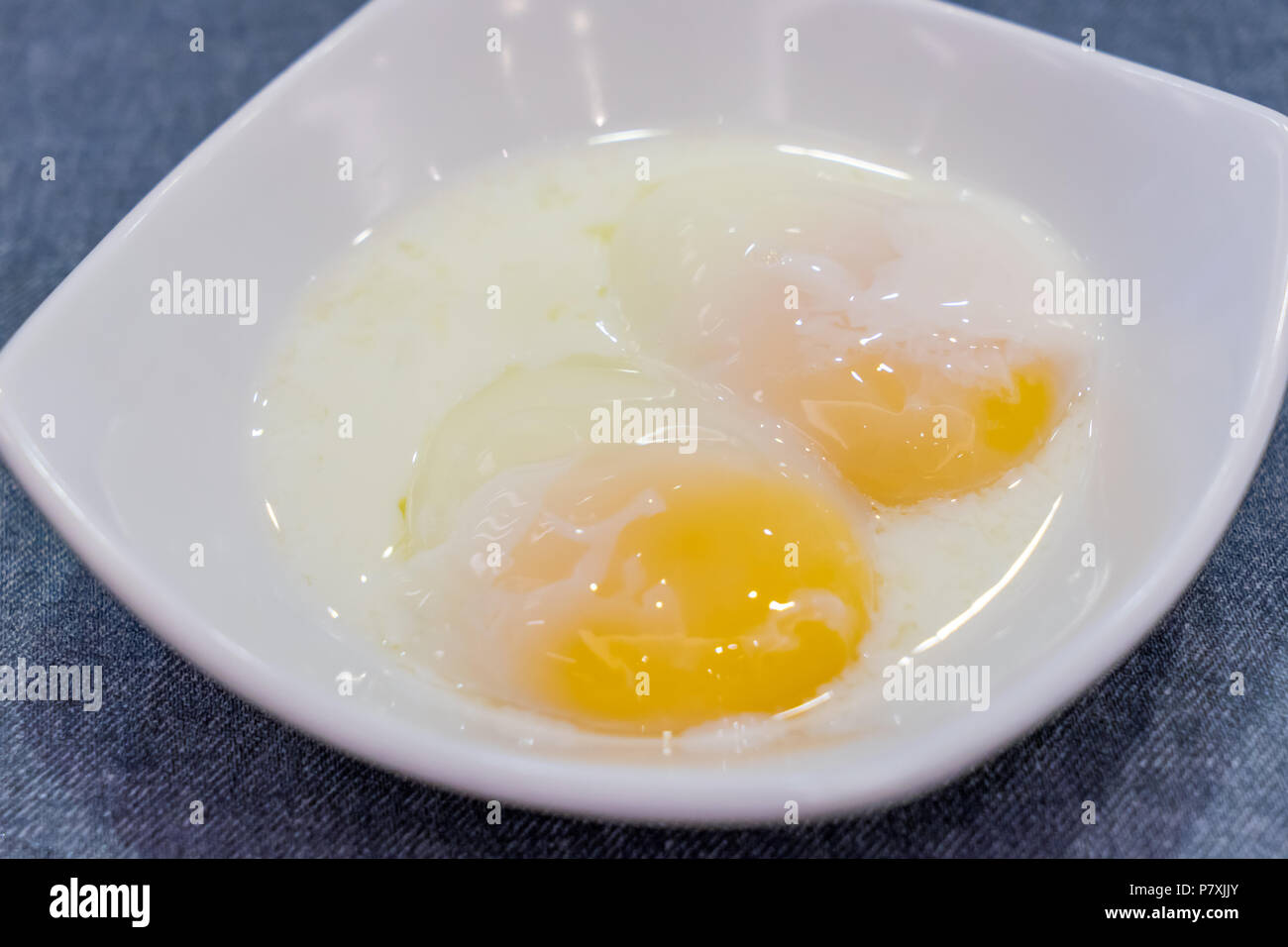 Half boiled eggs traditional Singapore breakfast called Kaya Toast, Selective Focus technique Stock Photo