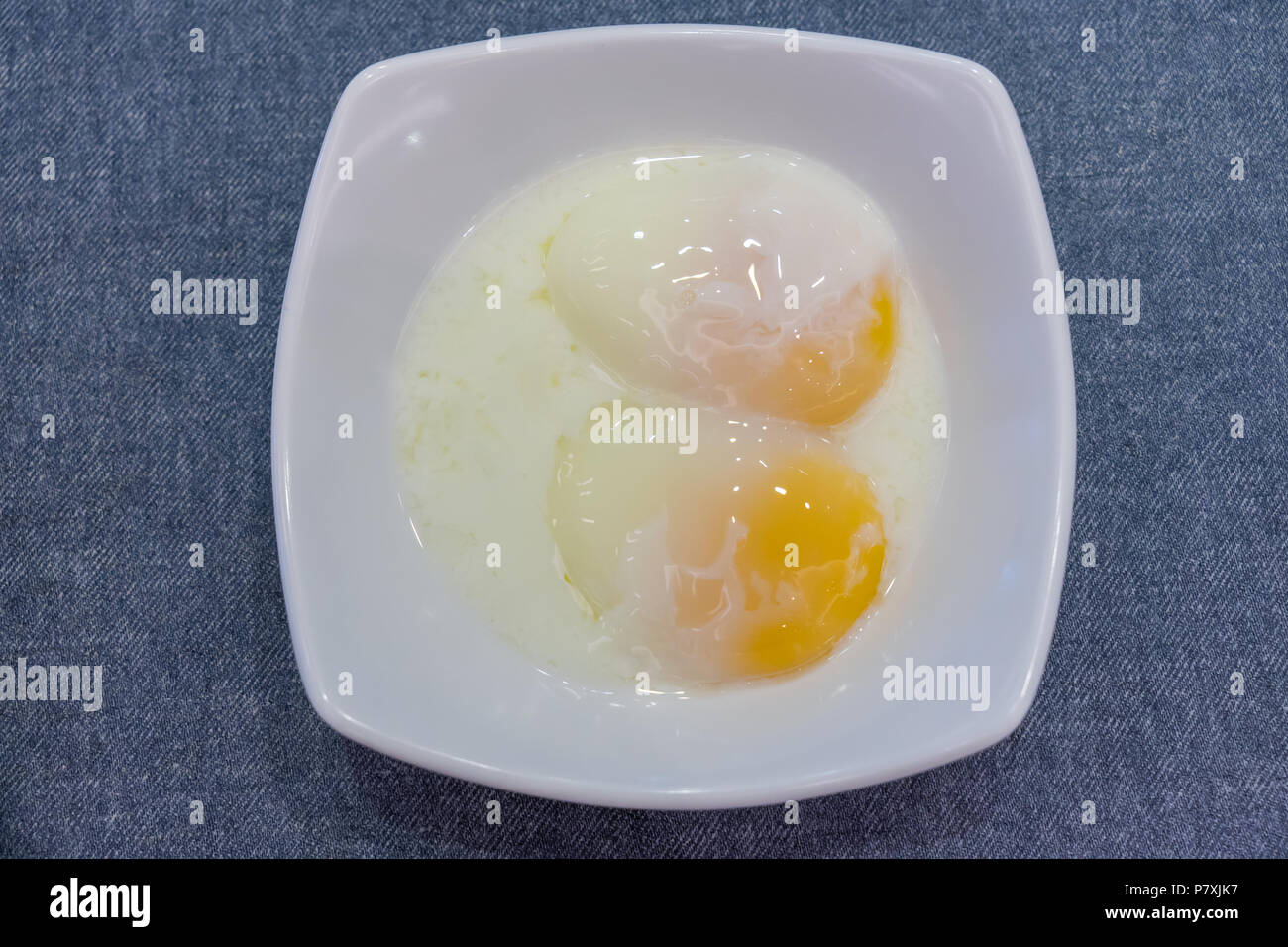 Half boiled eggs traditional Singapore breakfast called Kaya Toast, Selective Focus technique Stock Photo