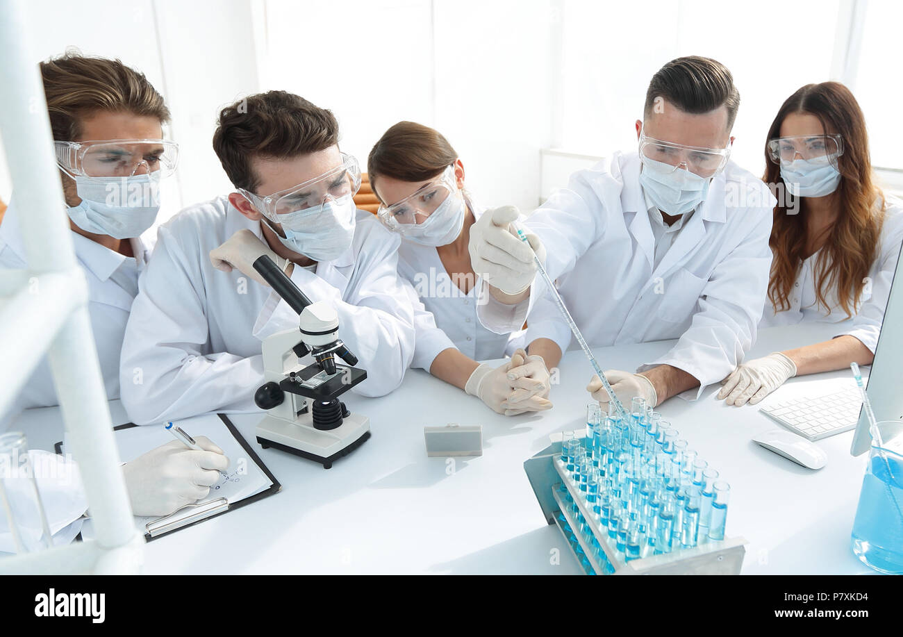 medical doctors are working with test tubes and microscope at the lab