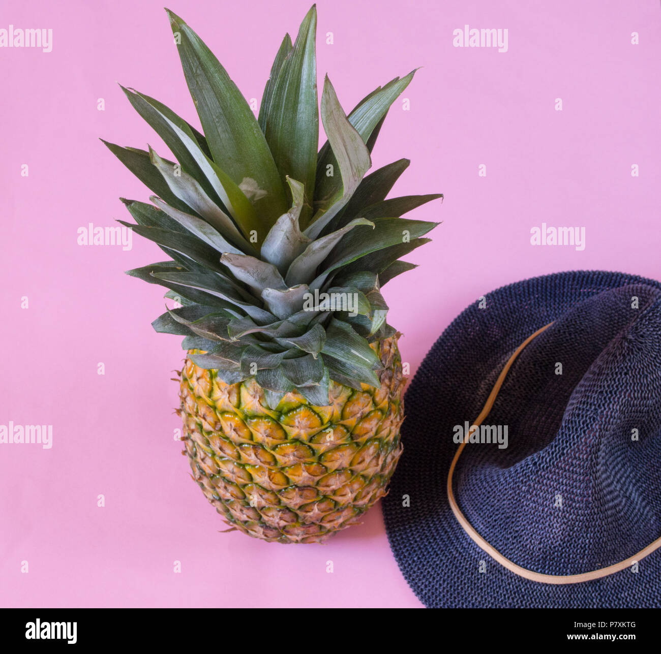Pineapple and blue hat  on pink background Stock Photo