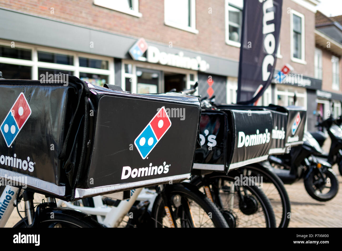 Delivery bikes of Domino's restaurant. Domino's is an American pizza restaurant chain founded in 1960. Stock Photo