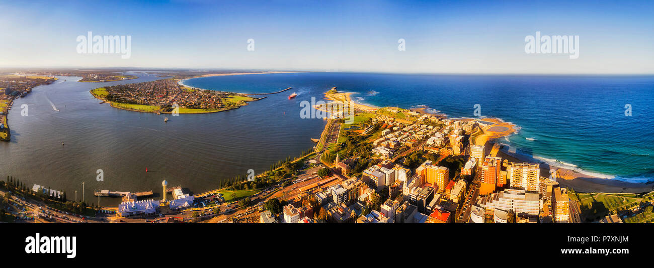 Hunter river enters pacific ocean between heads of Newcastle ciy in elevated aerial panorama of coastal region in Australia. Stock Photo