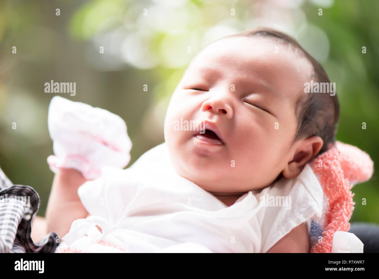 Newborn baby open her mouth in mother's hands, selective focus in her eyes, Family concept Stock Photo