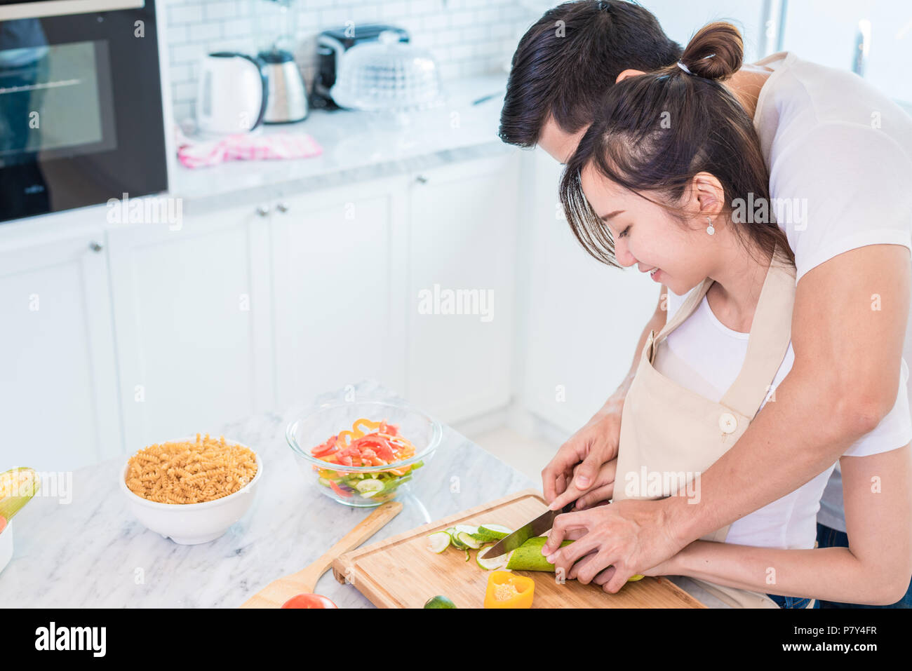 https://c8.alamy.com/comp/P7Y4FR/asian-young-lovers-or-couples-cooking-breakfast-in-the-morning-in-kitchen-room-man-teaching-woman-to-slice-vegetable-and-rice-relationship-and-famil-P7Y4FR.jpg