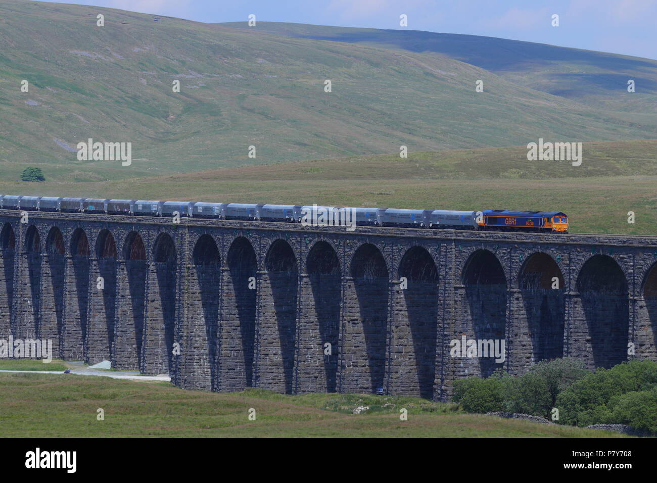A Great British Rail Freight (GBRf) train crosses the imressive victorian engineered Ribblehead Viaduct in North Yorkshire Stock Photo