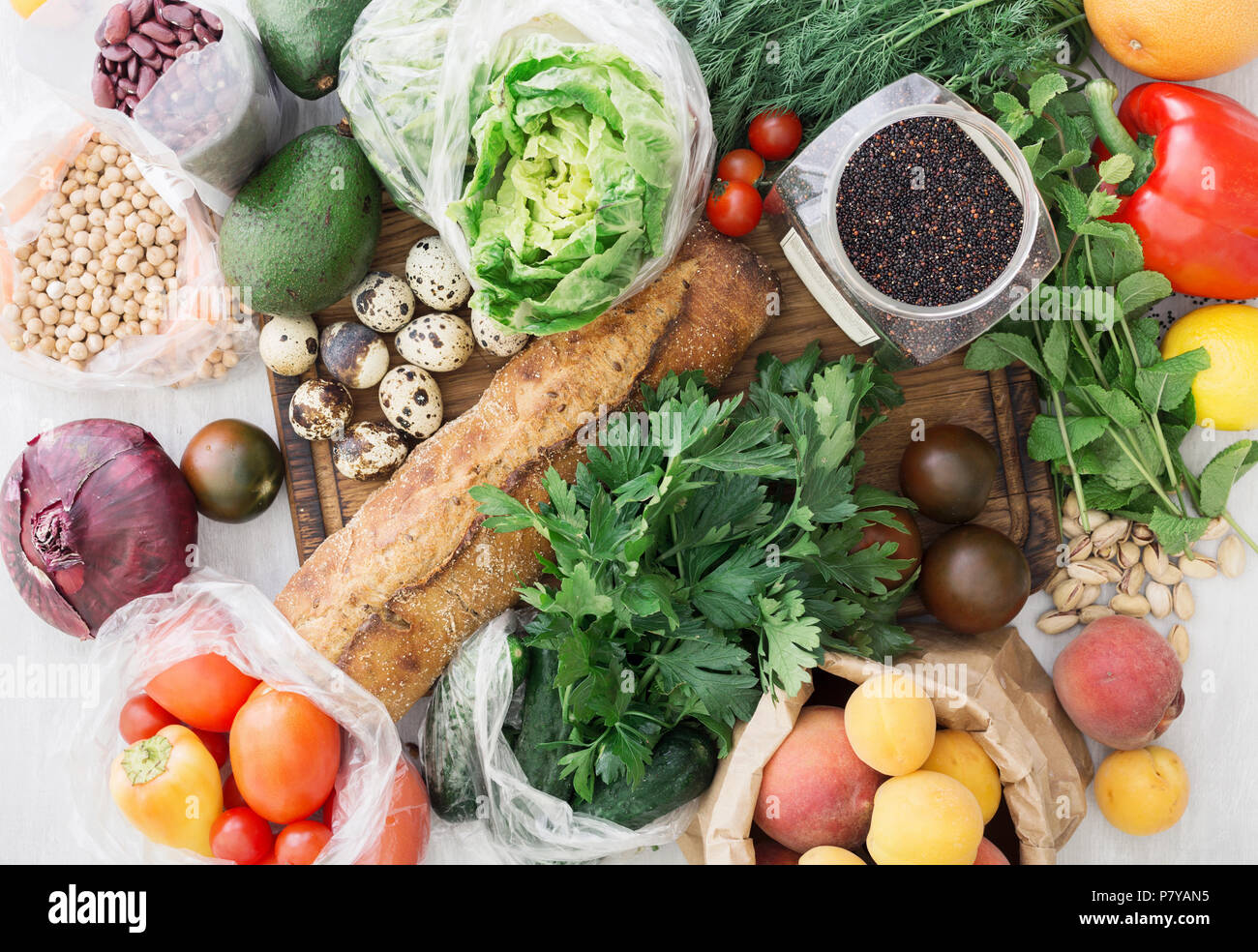 Set of healthy food. Cereals quinoa, chickpeas, beans, bread, various vegetables and fruits on a white wooden table, top view Stock Photo
