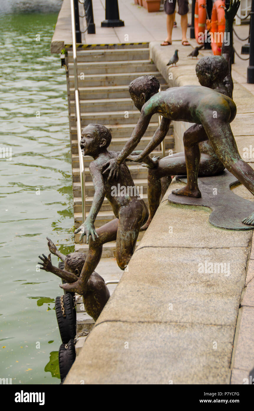 First Generation, a whimsical sculpture created by Chong Fah Cheong. Five boys jumping into Singapore River, showing the lighter side of everyday life Stock Photo