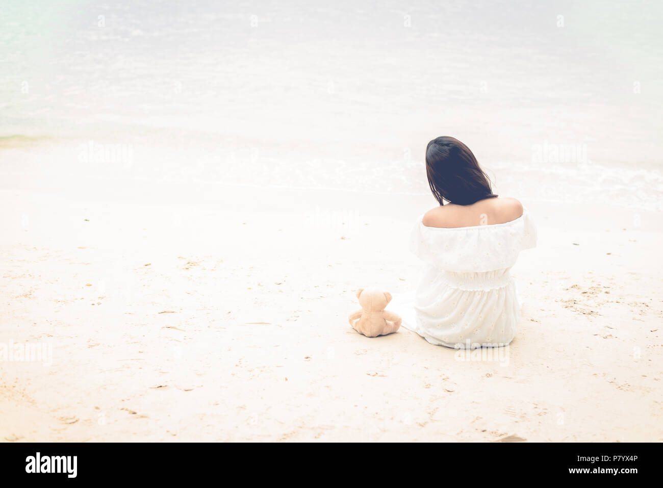 Asian woman waiting for love or somethings that make her happy. Lonely and Beauty concept. Back view scene of girl. Ocean and sea theme. Copy space in Stock Photo