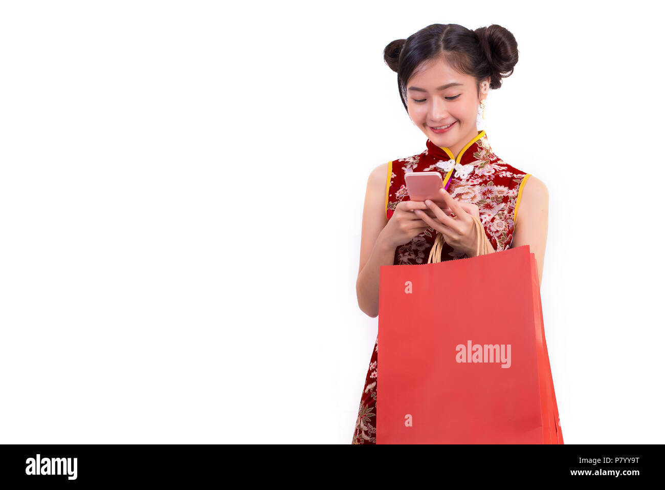 Young Asian beauty woman wearing cheongsam and using smart phone gesture in Chinese new year festival event on isolated white background. Technology a Stock Photo