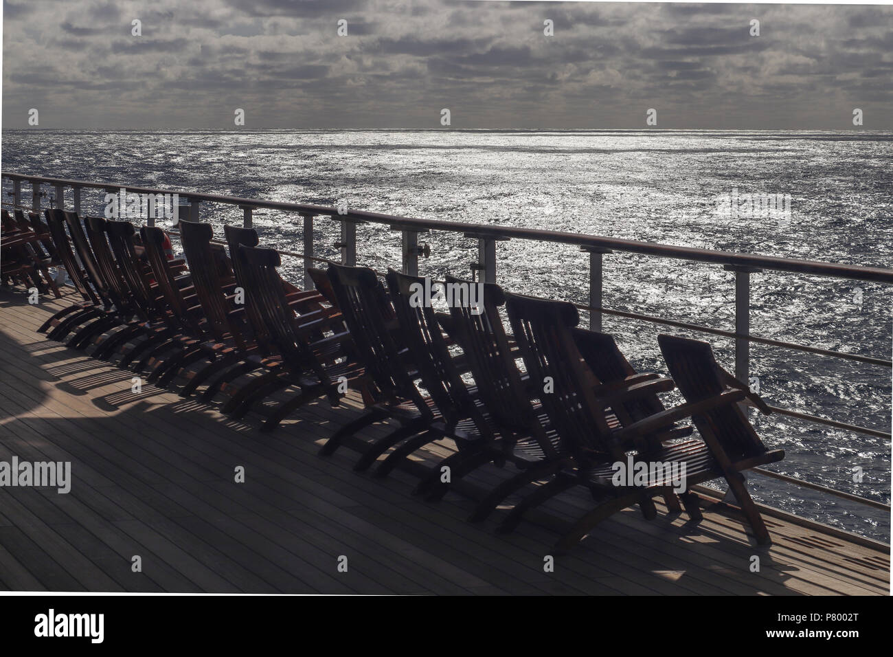 Many Deck Chairs Casting Shadows On The Deck Of An Ocean