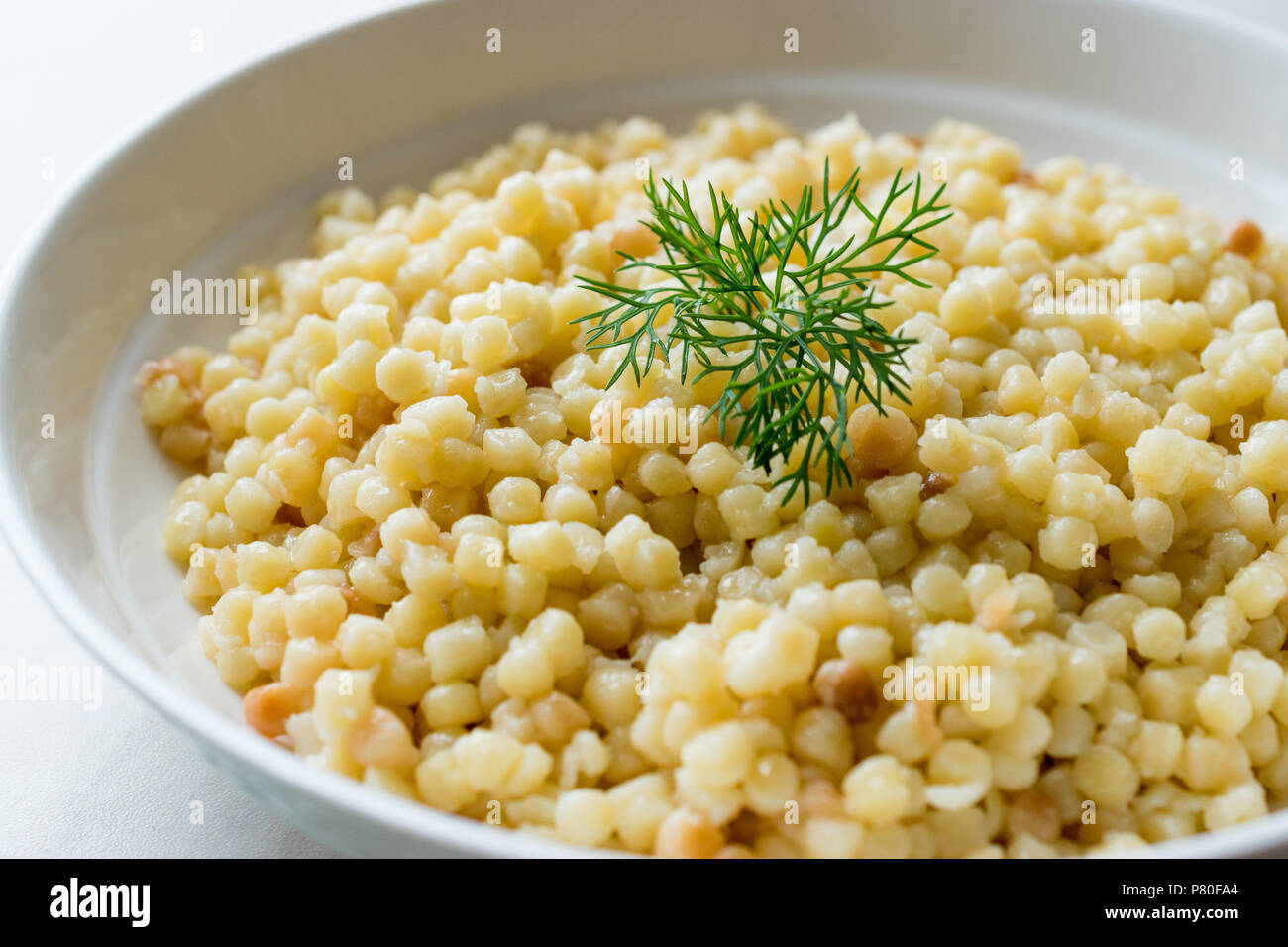 Cooked Couscous with Dill served in White Plate / Turkish Kuskus