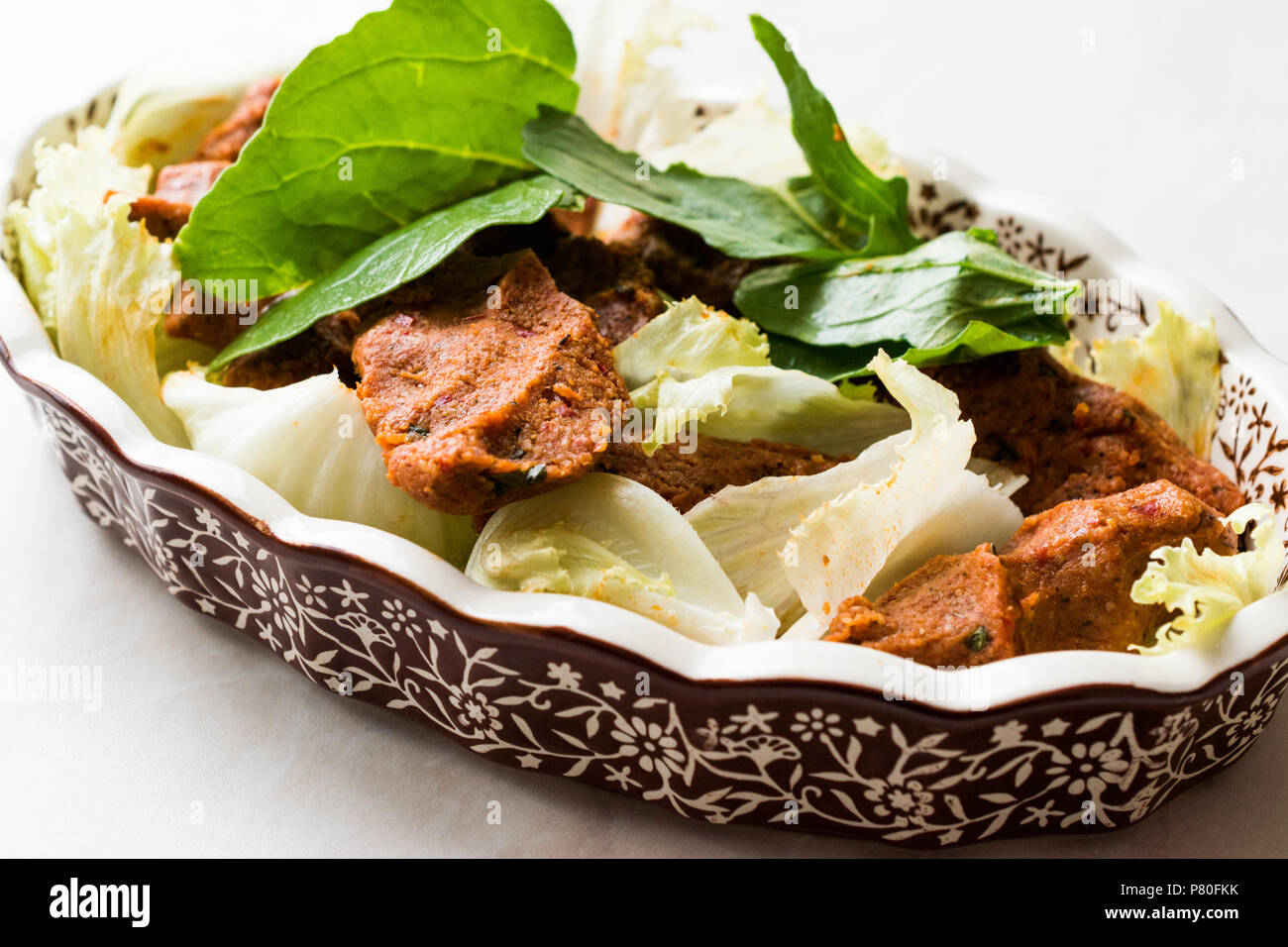 Turkish Food Cig Kofte with lettuce and Rocket Leaves or Arugula. Traditional Food. Stock Photo