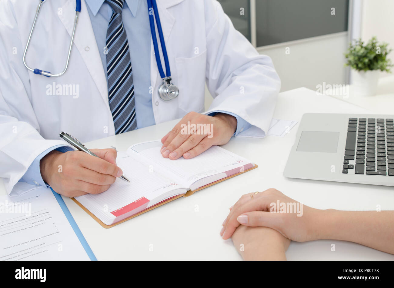 Doctor appoints the date of the next medical appointment. Patient and doctor in the office Stock Photo