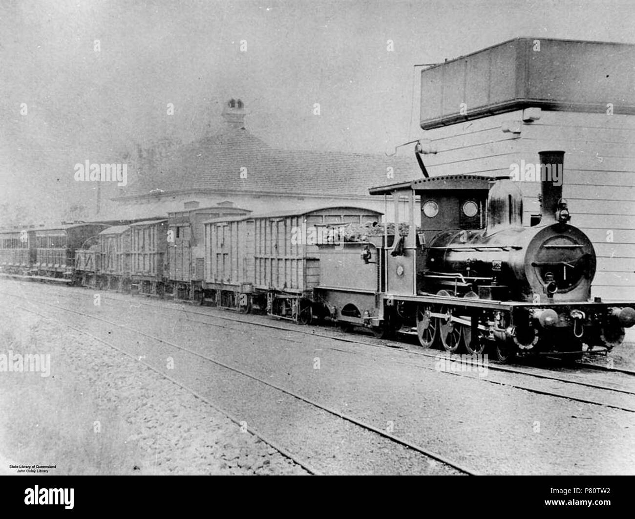 English: A steam train stopped at the Grandchester Railway Station, around 1879. 'The Grandchester Railway Station was built in 1866 and is the oldest station in Queensland and is listed by the National Trust. The colonial style building served as the station master's residence.' Information taken from: Grandchester State School, 2000, retrieved 10 January 2003, from www.grandchess.qld.edu.au . circa 1879 355 Steam train at Grandchester Railway Station, Queensland, ca. 1879 Stock Photo