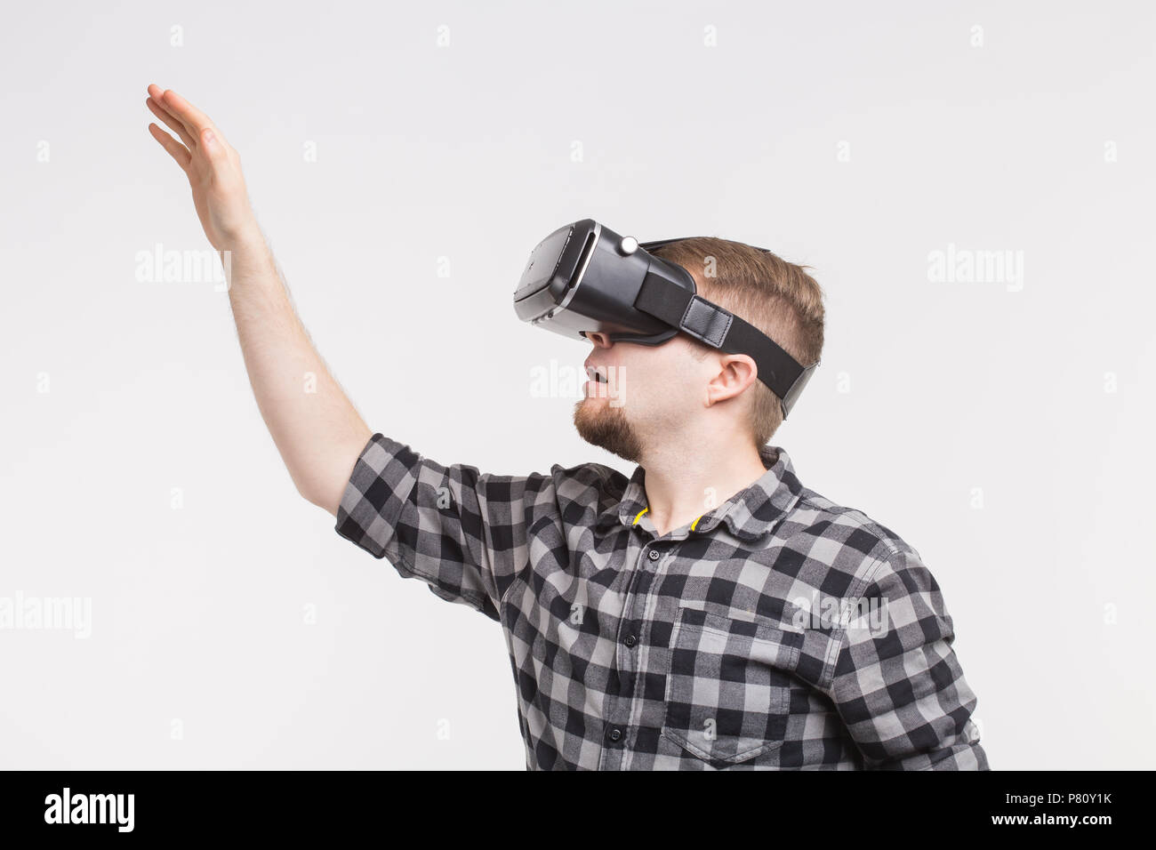 Man wearing virtual reality glasses raising his hand Stock Photo - Alamy