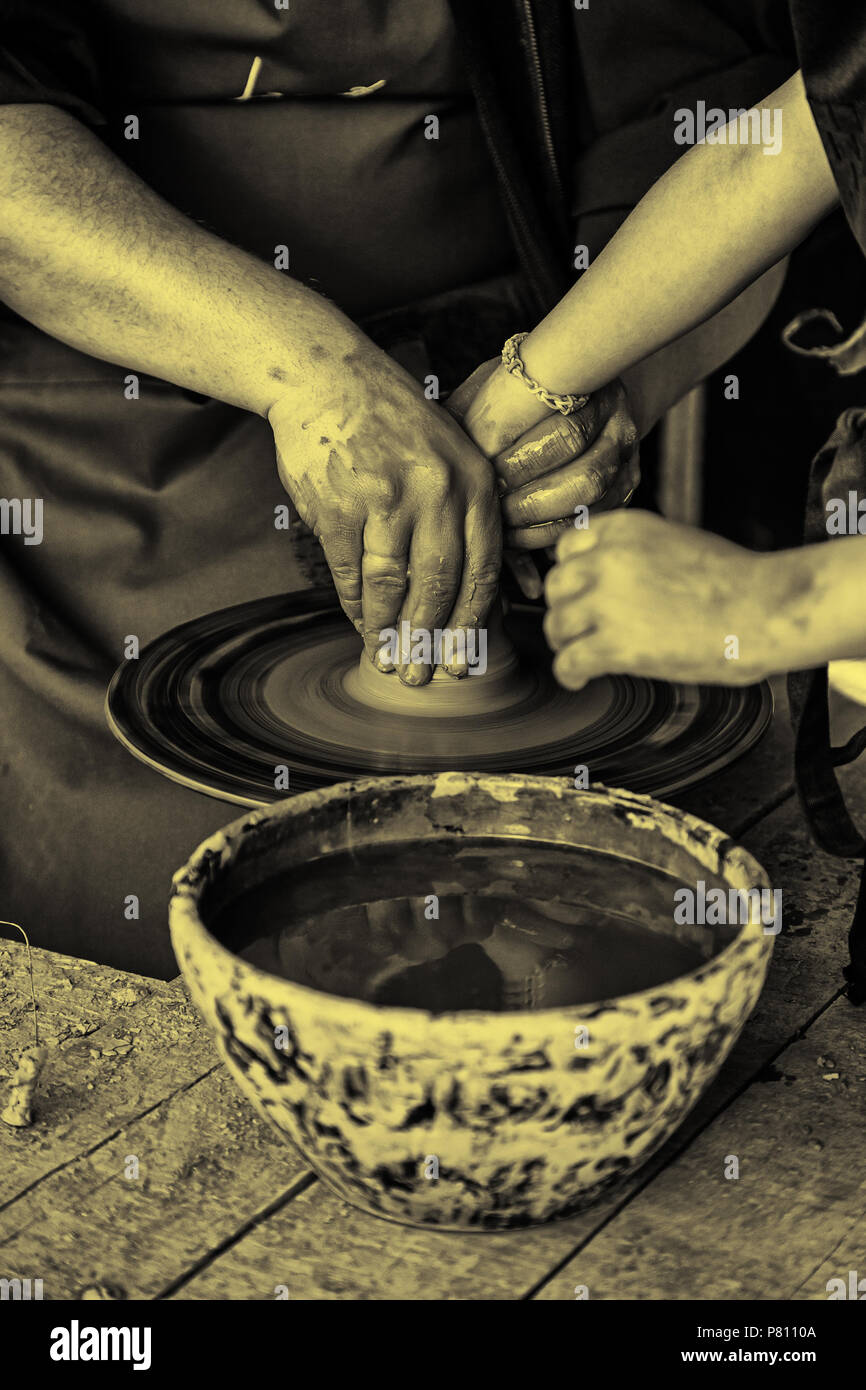 A close-up of a woman potter rolls a brown clay rolling pin on a special  fabric on a wooden table to make a plate and New Year's toys, on the table  li