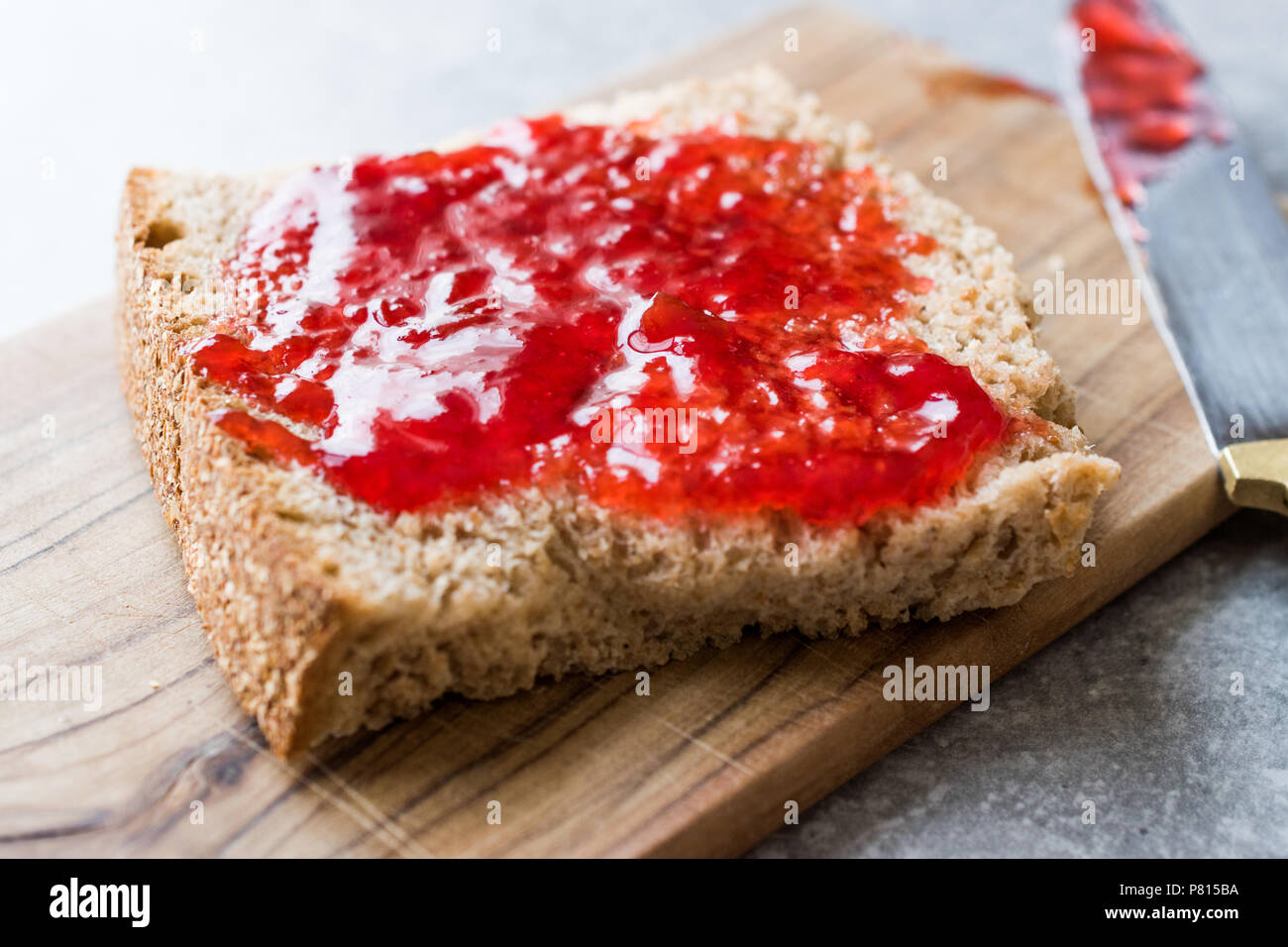 Red Plum Marmalade Jam with Bread and in glass Bowl. Organic Food. Stock Photo