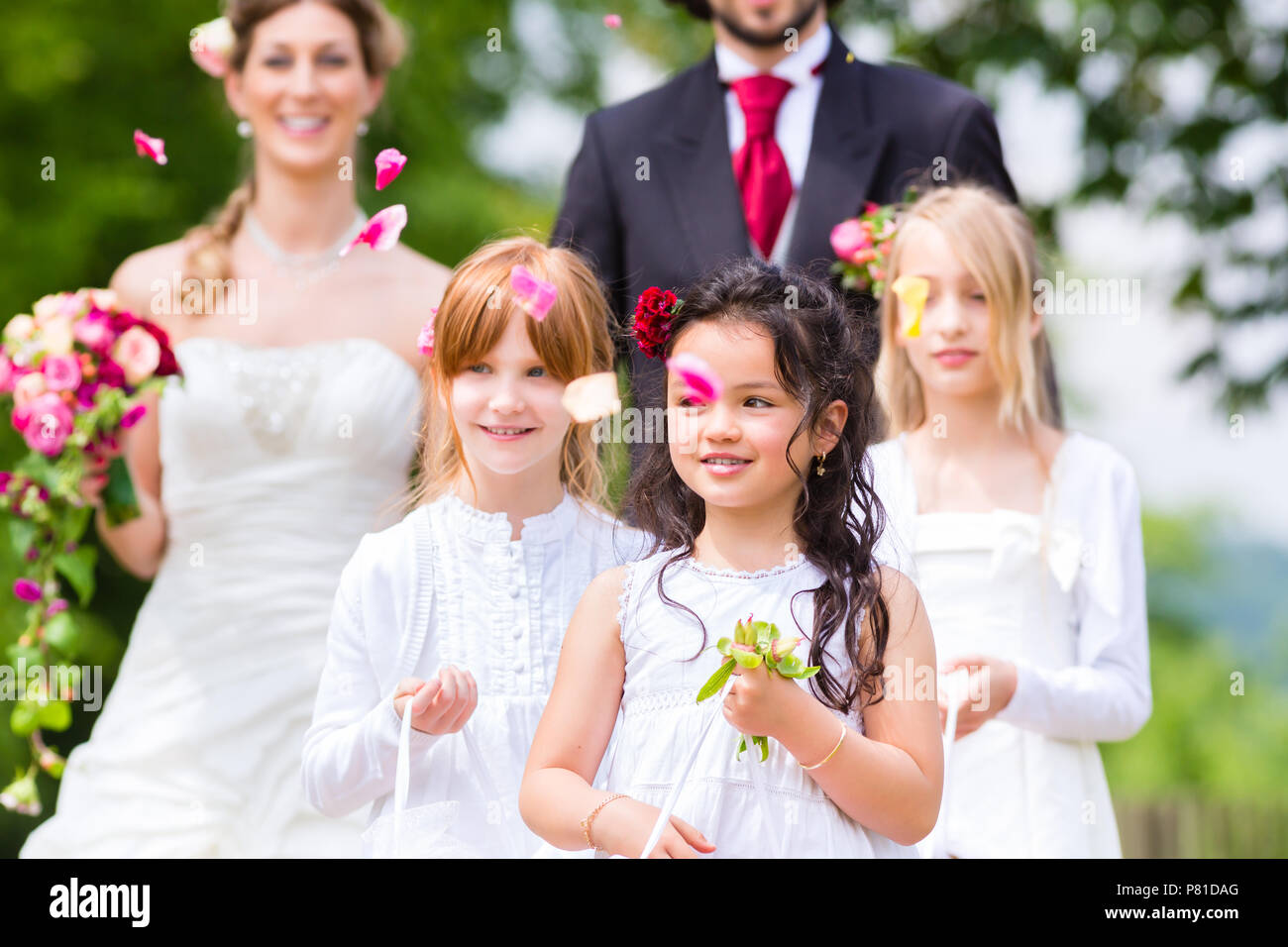 Wedding couple and bridesmaid showering flowers Stock Photo