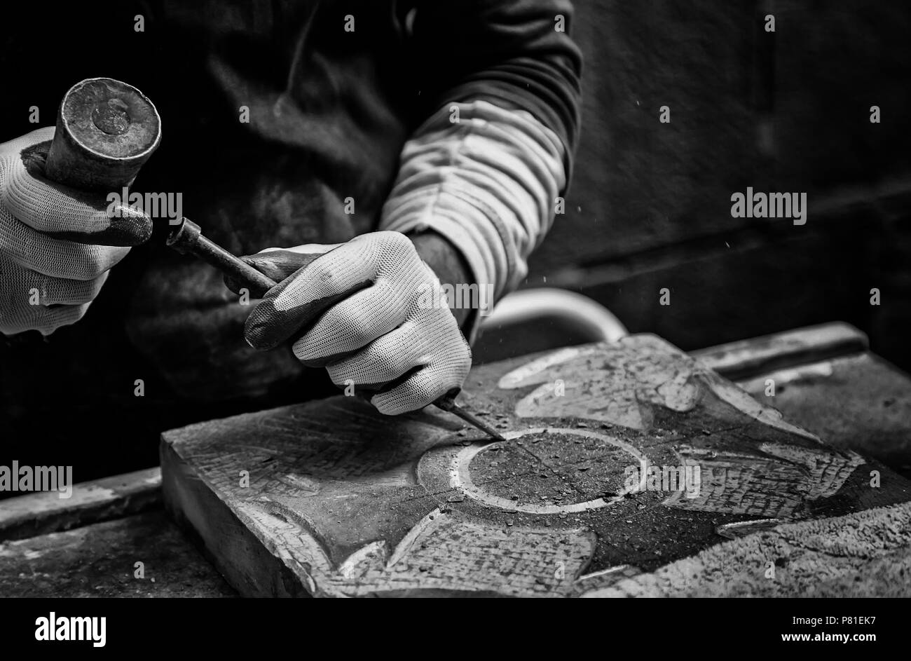 Man carving stone detail of a traditional craftsman working stone