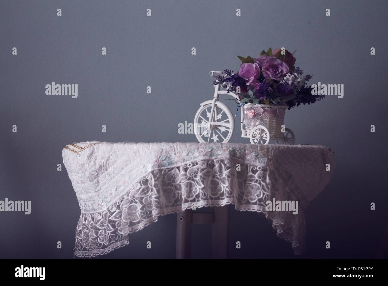 Conceptual still life of a table with lace cover and a vintage table top showing a calm winter aesthetic Stock Photo