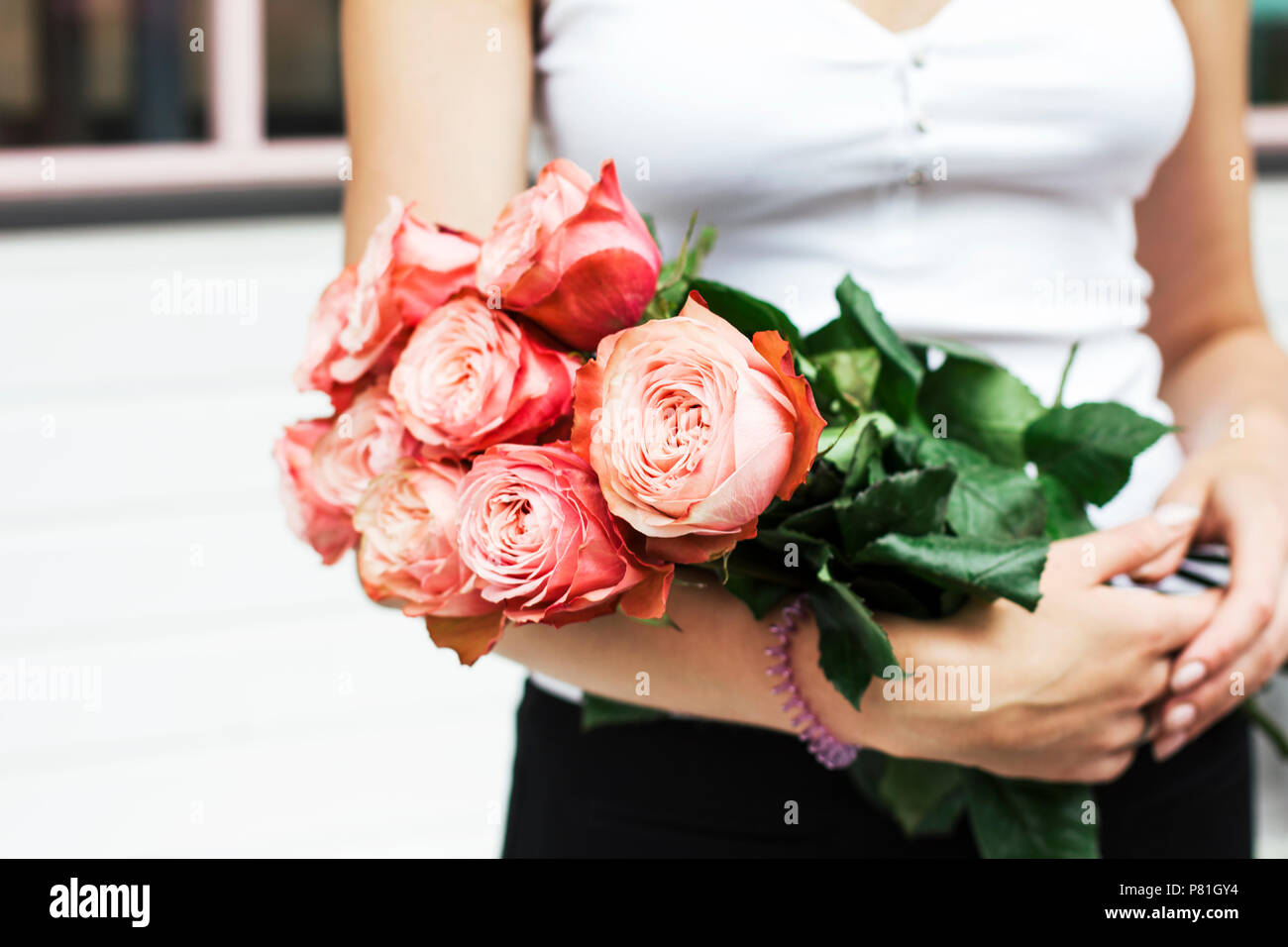 Young woman florist holding bouquet of pink roses at the street Stock ...