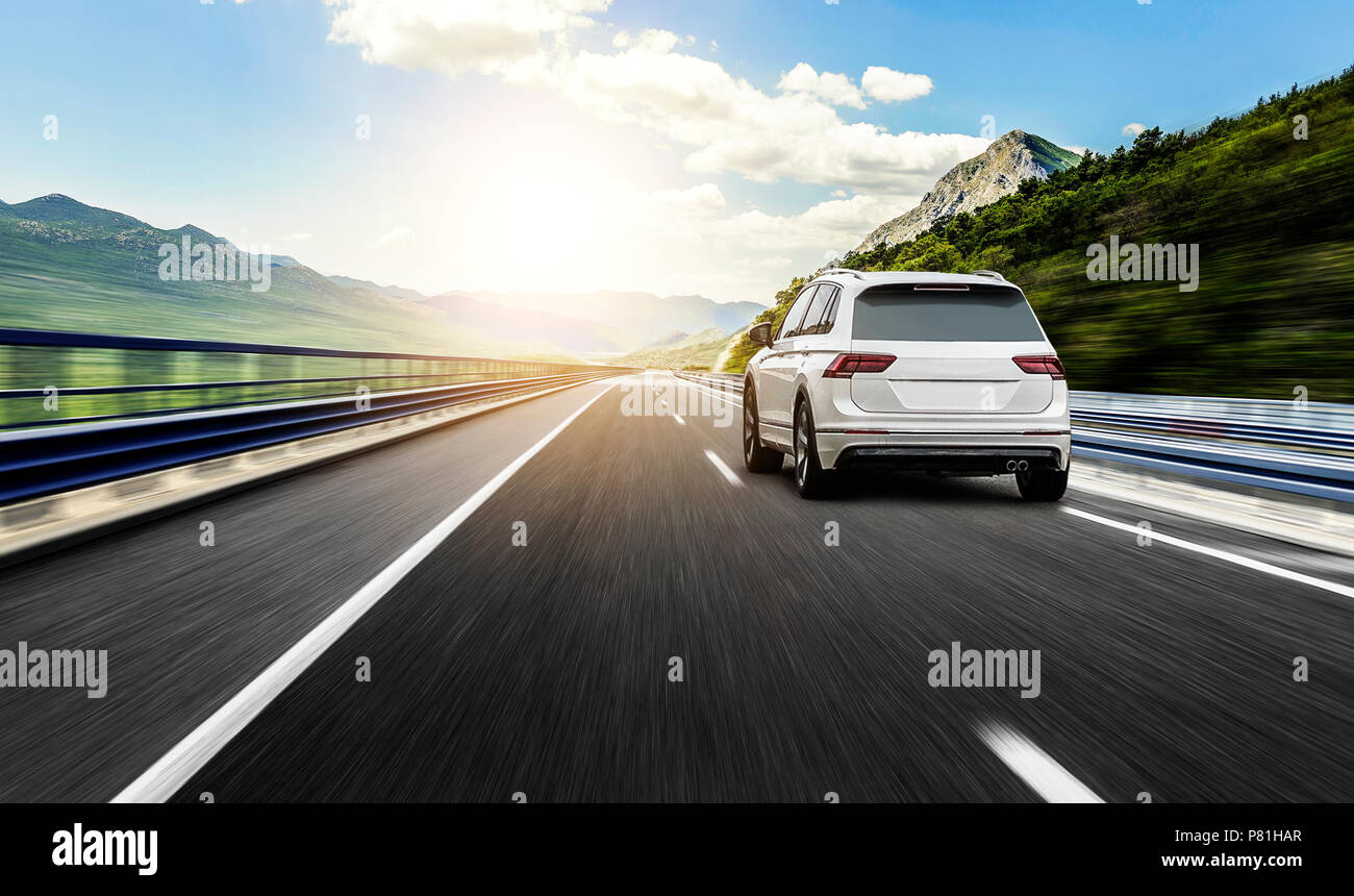 A white car rushing along a high-speed highway in the sun Stock Photo ...