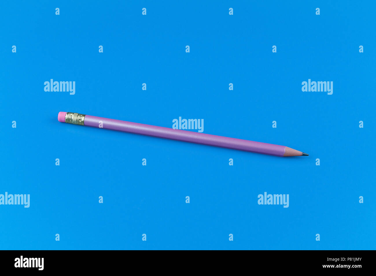 One purple pencil on a blue solid background. Stock Photo