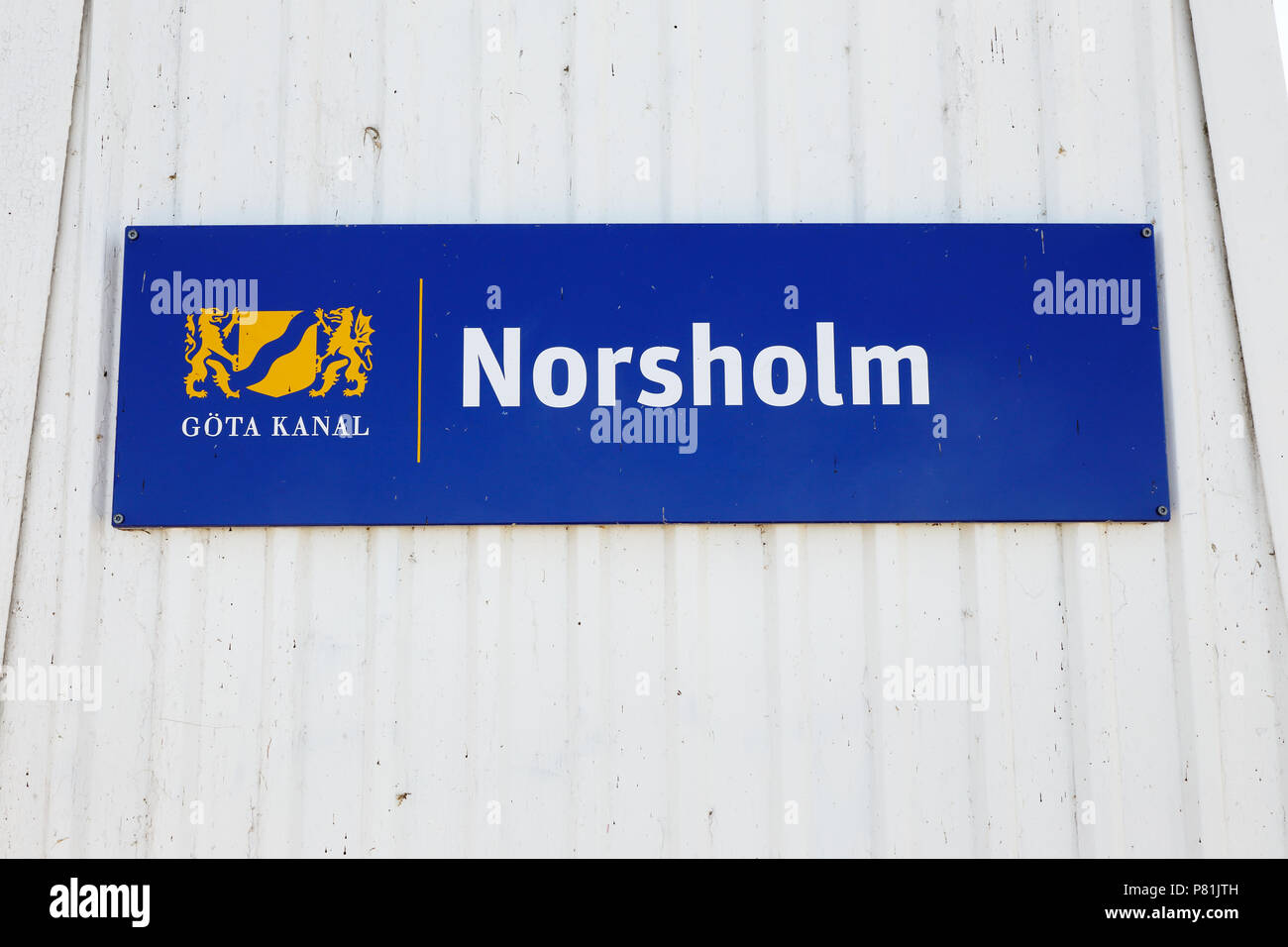 Norsholm, Sweden - July 5, 2018: Blue sign on white wooden wall at the entrance to the Norsholm locking aera in the Gota canal. Stock Photo