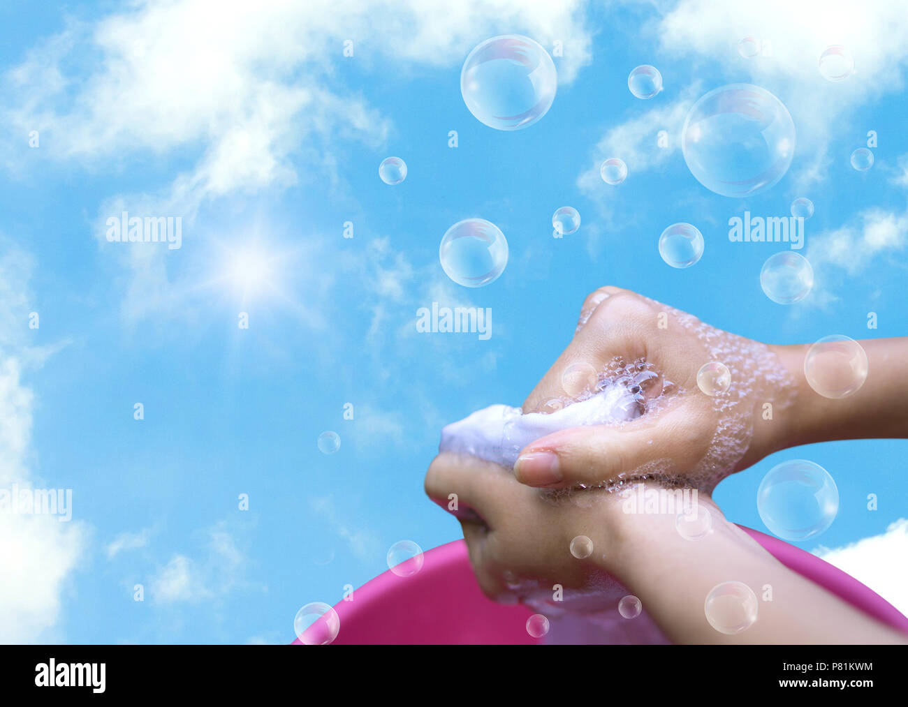 Female Hand washing clothes in the pink basin with clear Bubble soap